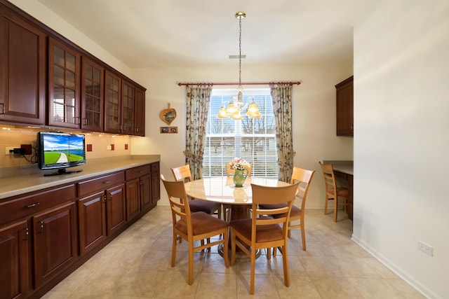 tiled dining space featuring an inviting chandelier