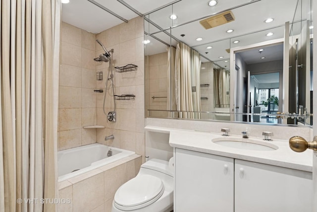 bathroom with toilet, visible vents, tiled shower / bath, and vanity