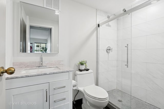 full bathroom with toilet, a shower stall, and vanity