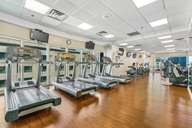 workout area with visible vents, a drop ceiling, and wood finished floors