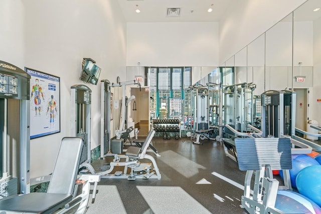 gym with a towering ceiling and visible vents