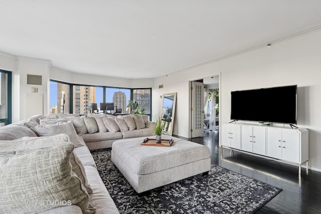 living room featuring dark wood-style floors, visible vents, crown molding, and baseboards