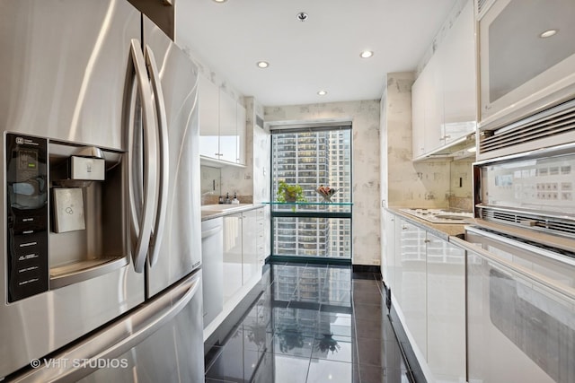 kitchen featuring recessed lighting, white cabinets, stainless steel fridge with ice dispenser, light countertops, and decorative backsplash