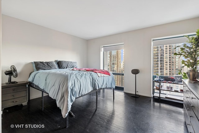 bedroom with dark wood finished floors and baseboards