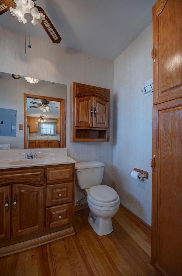 bathroom featuring ceiling fan, vanity, toilet, and hardwood / wood-style floors