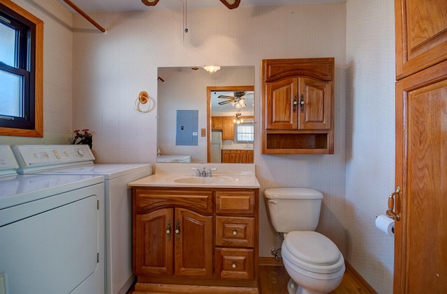 bathroom with ceiling fan, washing machine and dryer, electric panel, vanity, and toilet