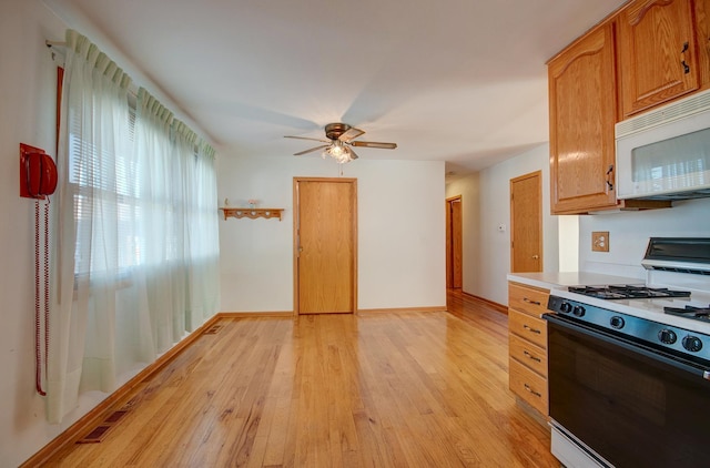 kitchen with ceiling fan, white appliances, and light hardwood / wood-style flooring