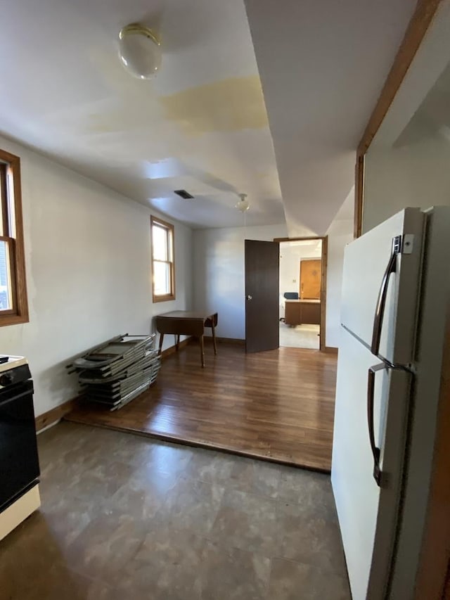 kitchen with white fridge, dark wood-type flooring, and electric stove