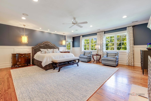 bedroom with ornamental molding, hardwood / wood-style floors, and ceiling fan