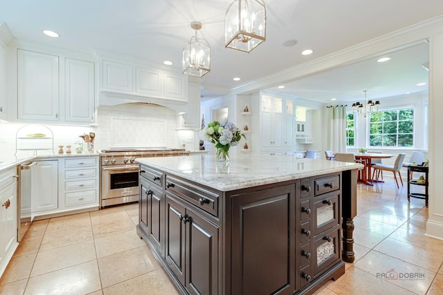 kitchen with dark brown cabinets, appliances with stainless steel finishes, a notable chandelier, decorative backsplash, and white cabinets