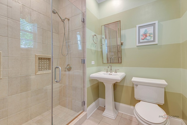 bathroom featuring a shower with door, tile patterned floors, and toilet