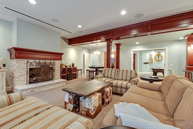 carpeted living room with a fireplace and decorative columns