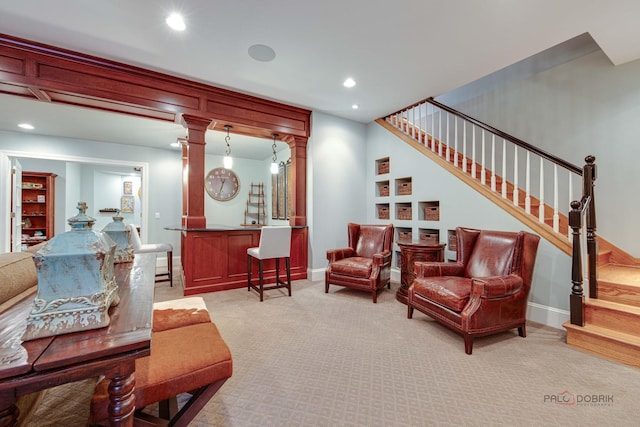 carpeted living room with decorative columns