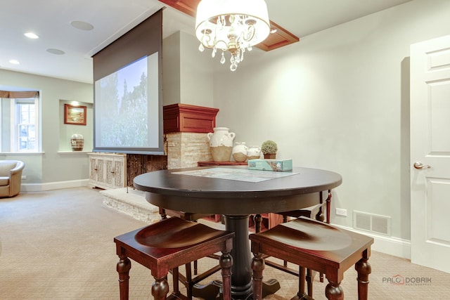 dining space with light carpet and an inviting chandelier