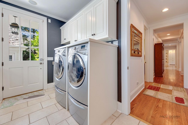 washroom with separate washer and dryer, light tile patterned floors, ornamental molding, and cabinets