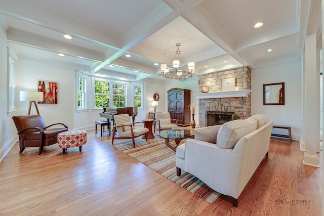 living room with coffered ceiling, beam ceiling, a fireplace, and light hardwood / wood-style flooring