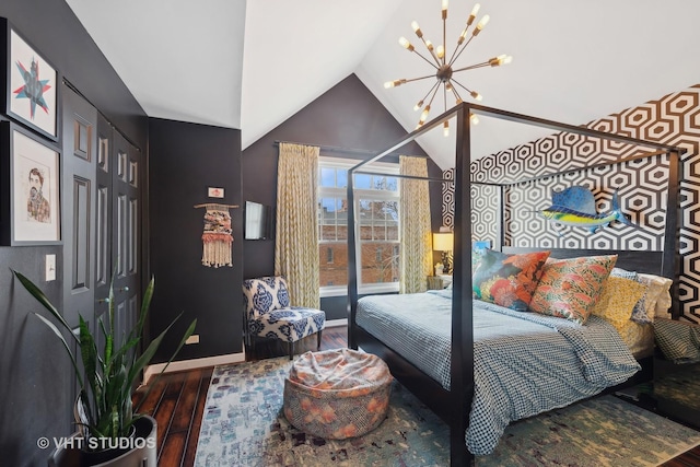 bedroom with vaulted ceiling, hardwood / wood-style floors, and a notable chandelier