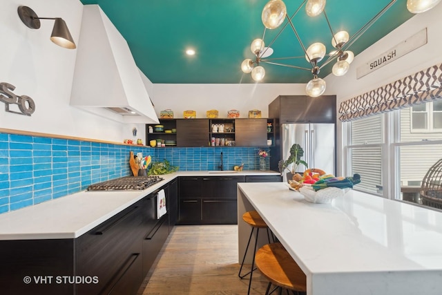 kitchen featuring appliances with stainless steel finishes, a center island, sink, and custom exhaust hood