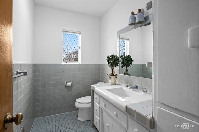 bathroom with vanity, tile patterned flooring, tile walls, and toilet