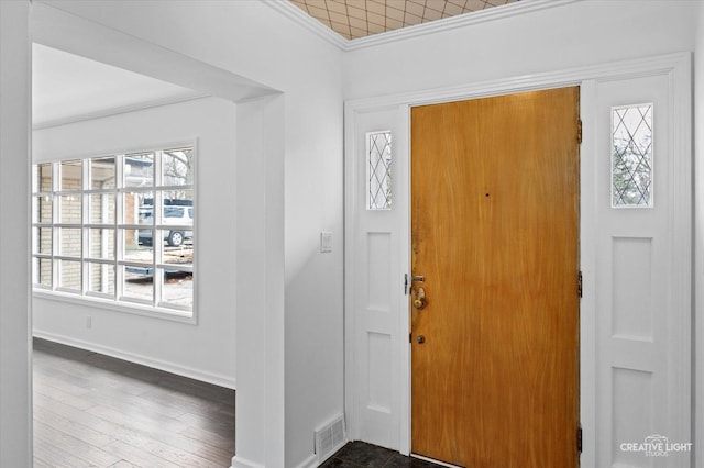 foyer entrance featuring ornamental molding, a healthy amount of sunlight, and hardwood / wood-style floors