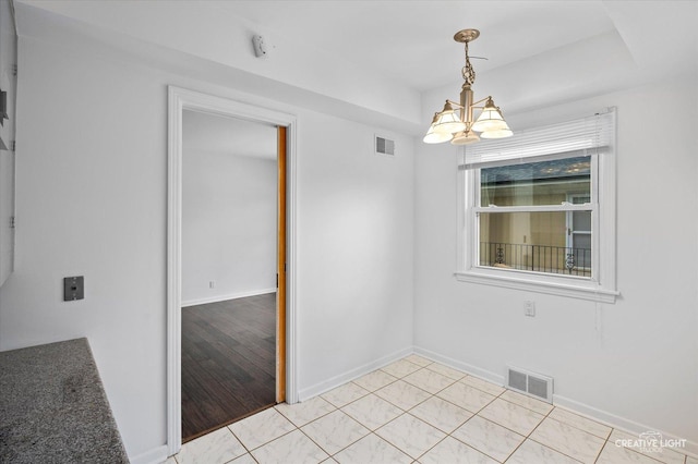 spare room featuring light tile patterned flooring and an inviting chandelier