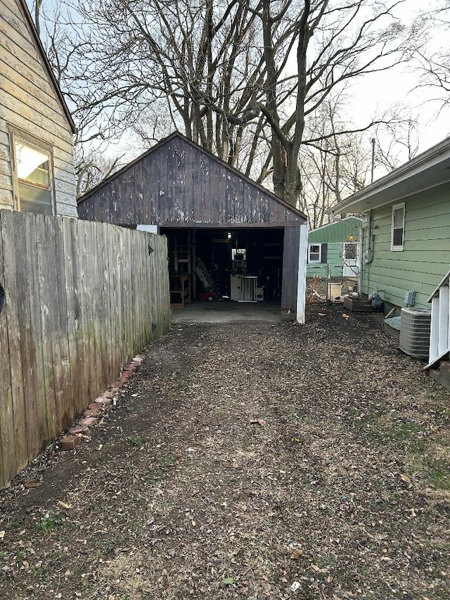 view of yard featuring a garage, an outbuilding, and central air condition unit