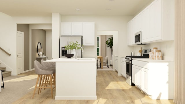 kitchen featuring a kitchen island with sink, sink, stainless steel appliances, and white cabinets