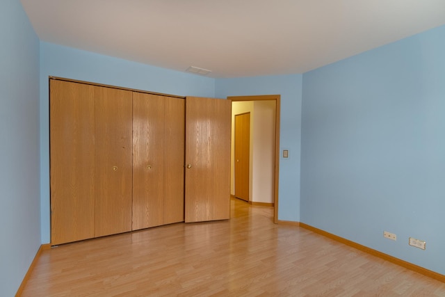 unfurnished bedroom featuring a closet and light hardwood / wood-style flooring