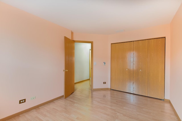 unfurnished bedroom featuring light hardwood / wood-style floors and a closet