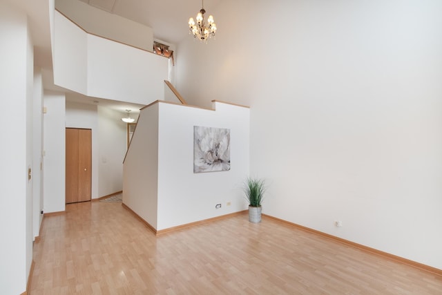 interior space featuring a high ceiling, an inviting chandelier, and light hardwood / wood-style floors