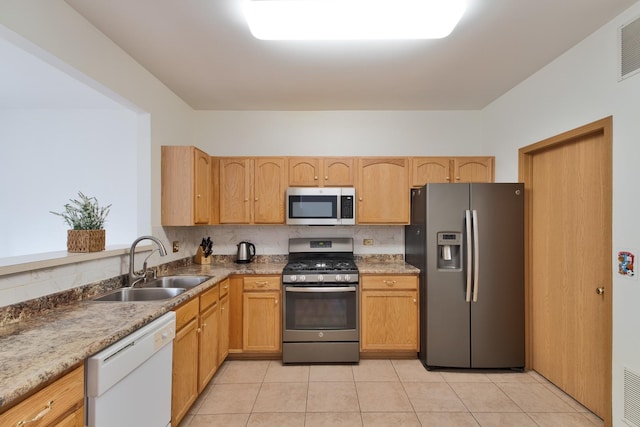 kitchen with light brown cabinetry, sink, light tile patterned flooring, and appliances with stainless steel finishes