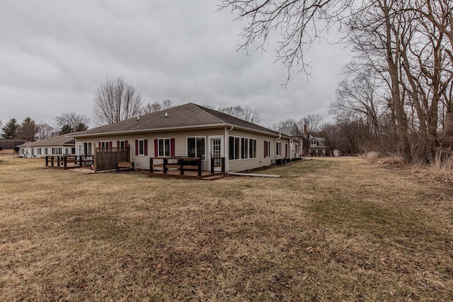 rear view of house with a deck and a lawn