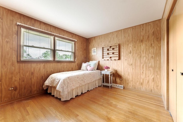 bedroom featuring wood-type flooring and wooden walls