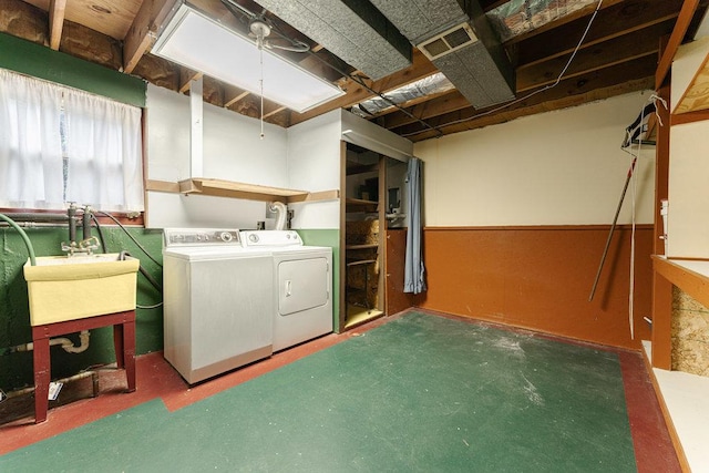 clothes washing area featuring sink and washer and dryer