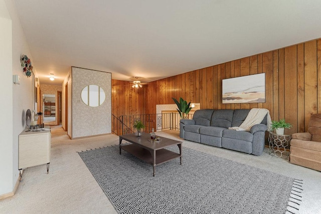 living room with light colored carpet, ceiling fan, and wood walls