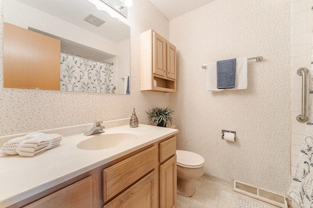 bathroom featuring vanity, toilet, and walk in shower