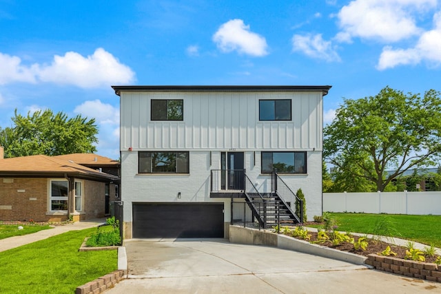 4932 Brummel St, Skokie, IL 60077 - view of front of house with board and batten siding, an attached garage, concrete driveway, and brick siding