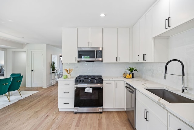 4932 Brummel St, Skokie, IL 60077 - kitchen featuring appliances with stainless steel finishes, light stone counters, recessed lighting, decorative backsplash, and light wood-style flooring
