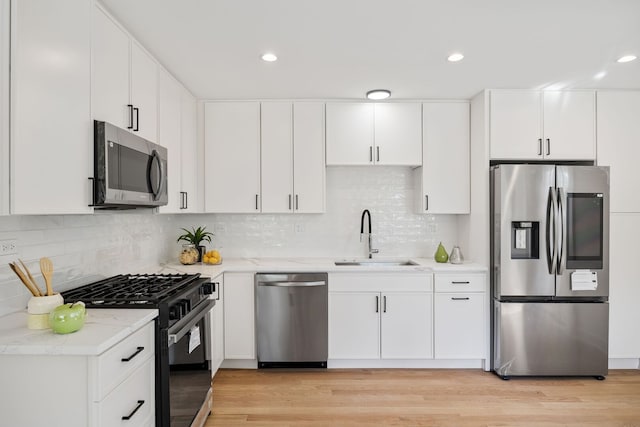 4932 Brummel St, Skokie, IL 60077 - kitchen featuring appliances with stainless steel finishes, decorative backsplash, light wood-style flooring, white cabinets, and recessed lighting
