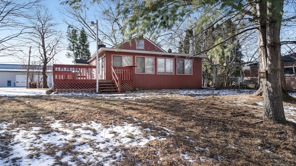 snow covered back of property with a deck