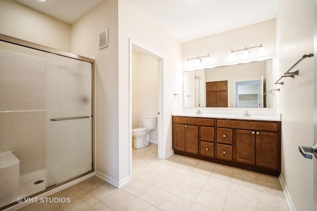 bathroom featuring vanity, toilet, tile patterned flooring, and a shower with door