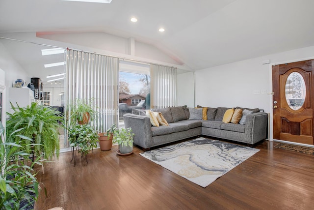 living room with dark hardwood / wood-style floors and vaulted ceiling with skylight