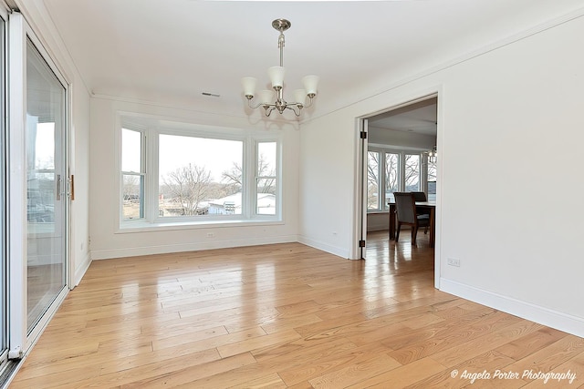 unfurnished dining area featuring a chandelier and light wood-type flooring