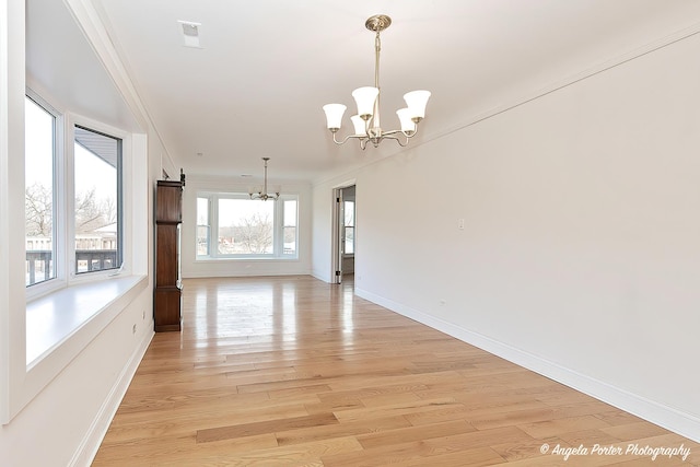 interior space featuring crown molding, a chandelier, and light hardwood / wood-style floors