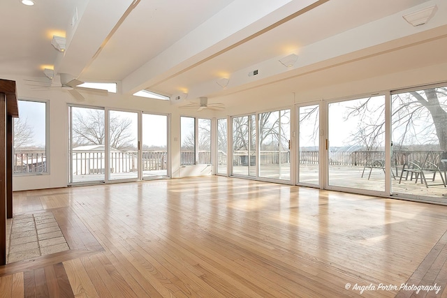 unfurnished sunroom with beamed ceiling and ceiling fan