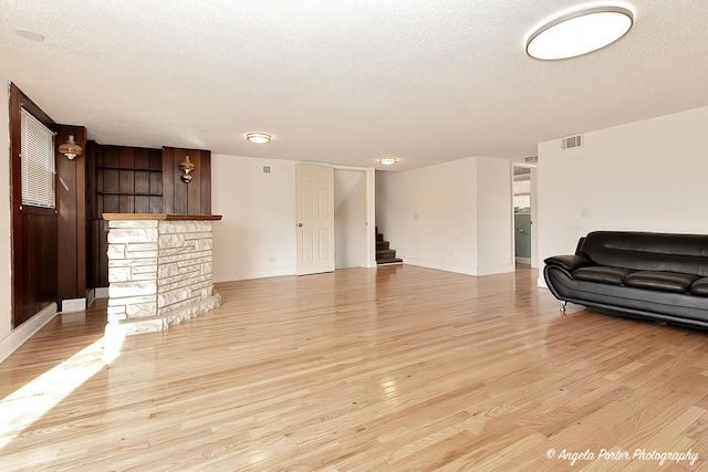 living room featuring a textured ceiling and light hardwood / wood-style floors