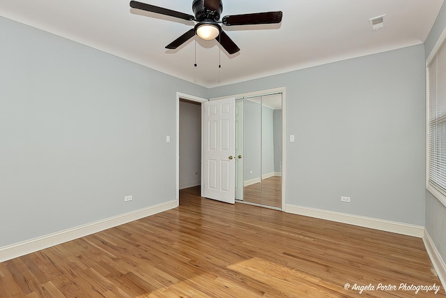 unfurnished bedroom featuring ceiling fan, light wood-type flooring, and a closet