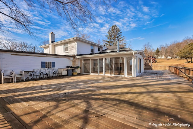 back of property featuring a deck and a sunroom