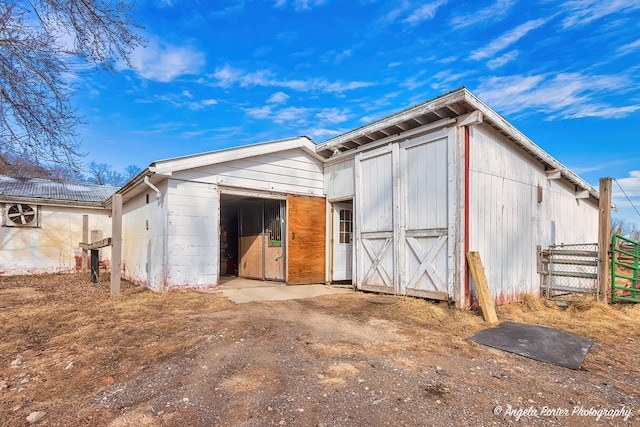 back of house featuring an outbuilding