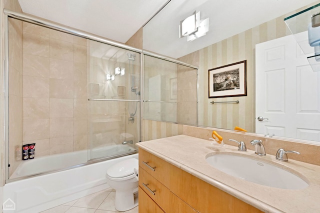 full bathroom with toilet, tile patterned floors, bath / shower combo with glass door, and vanity